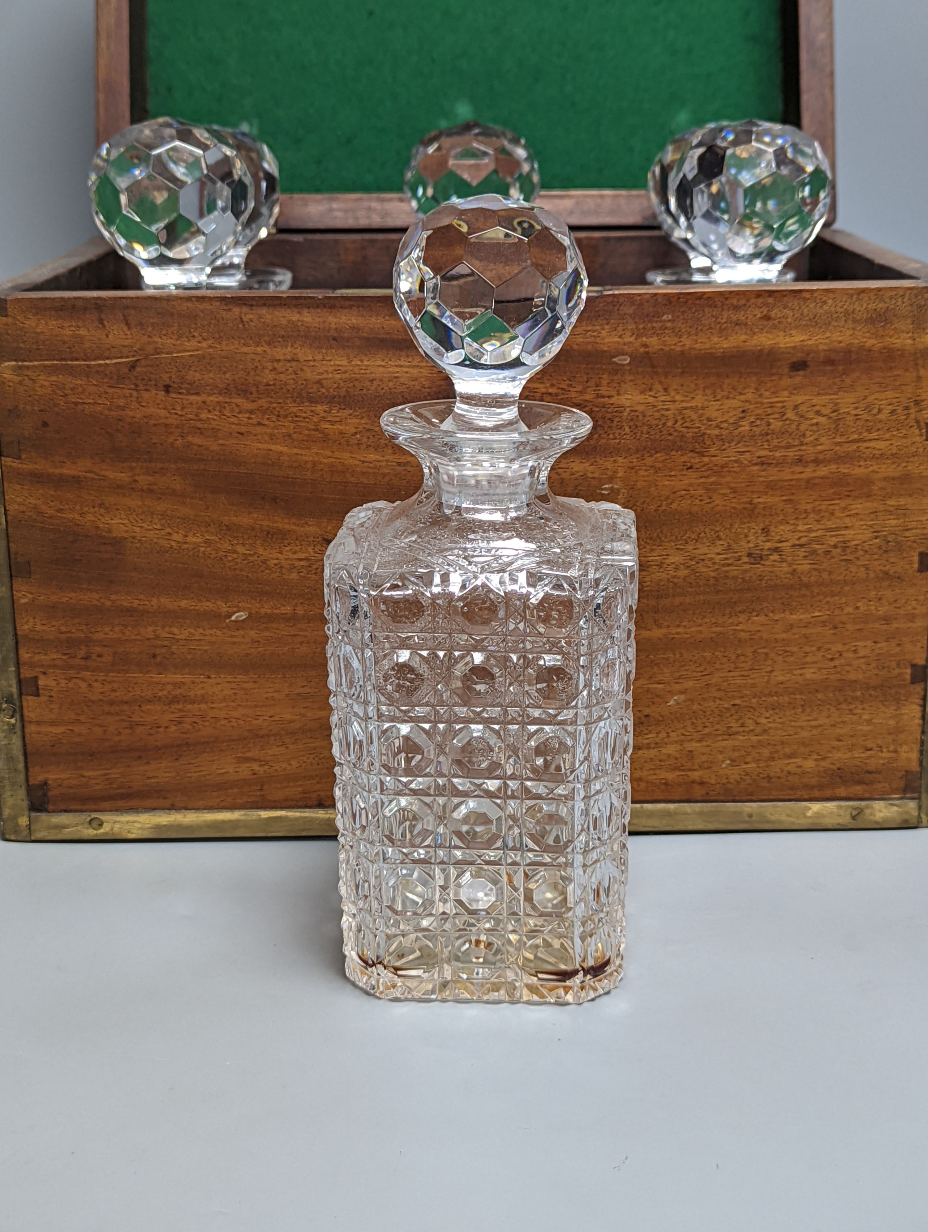 A brass bound mahogany six bottle decanter box, containing 6 cut glass decanters